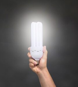 Eine Hand hält im Dunkeln eine hell leuchtende Lichtquelle